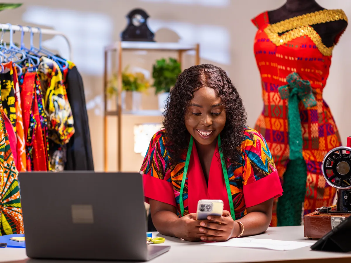 A young fashion entrepreneur running her studio from a laptop and phone